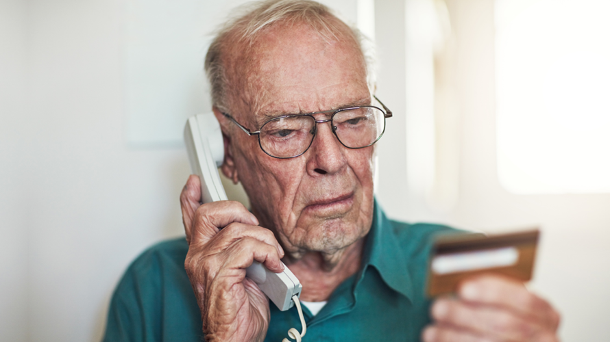 elderly man with credit card and phone